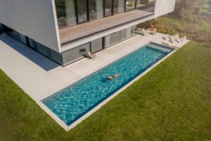 Langwerpig modern zwembad naast een modern huis
